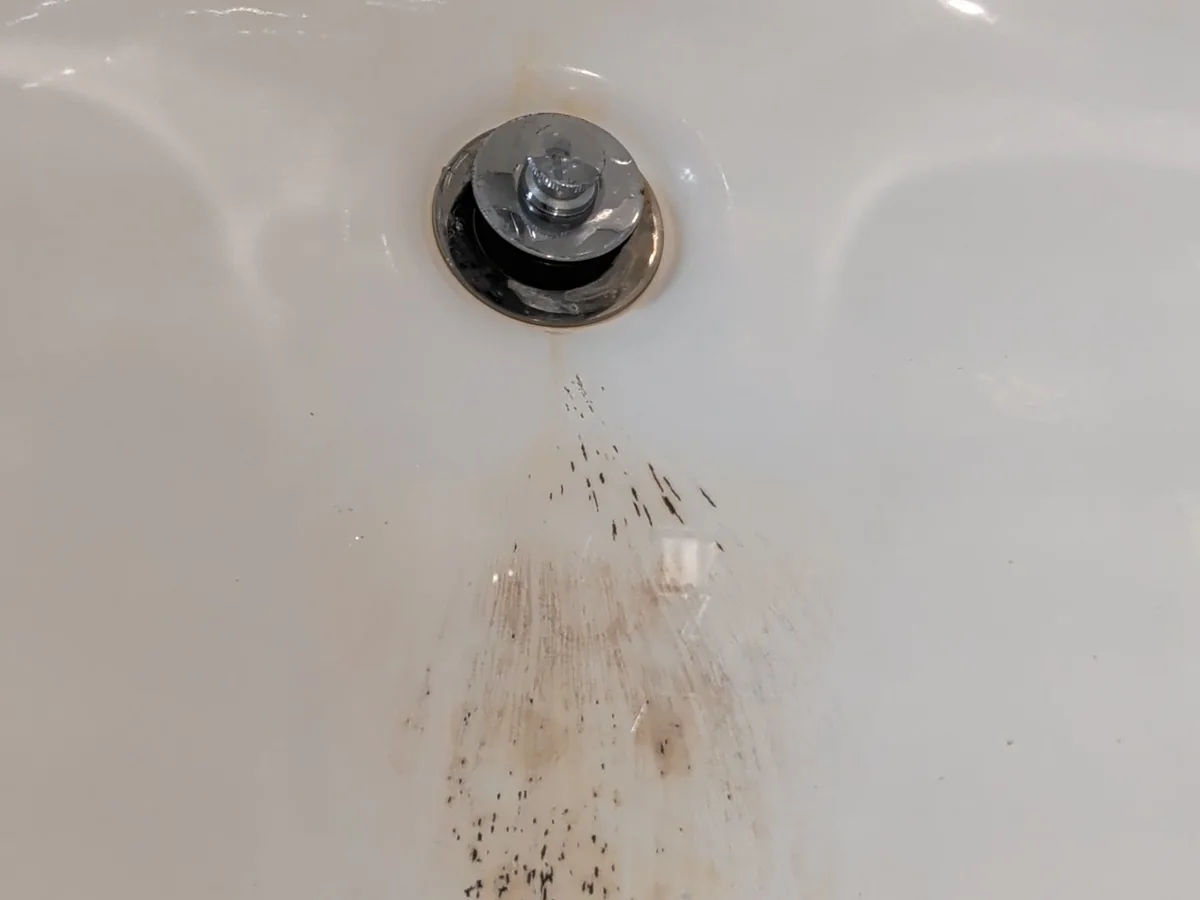 Bathtub surface damage near the drain before repair in Allen, Texas