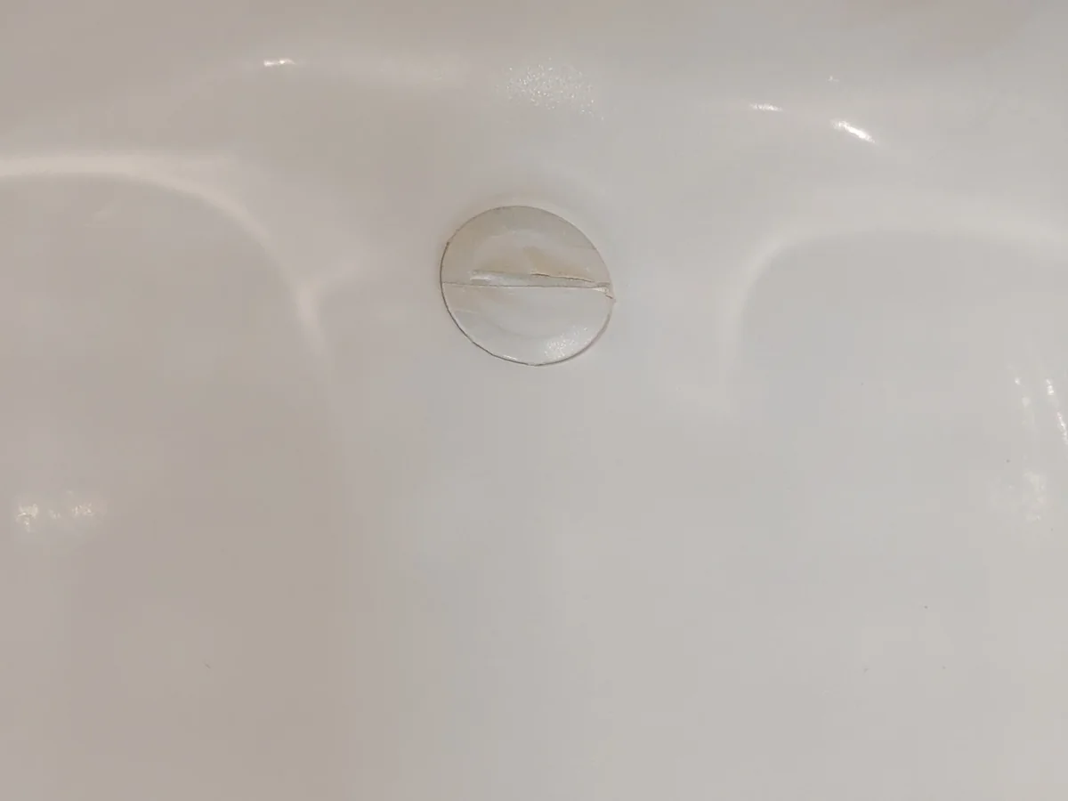 Bathtub surface near the drain after localized repair in Allen, Texas