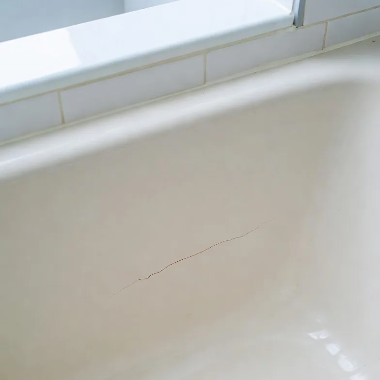Before photo of a bathtub crack repair area