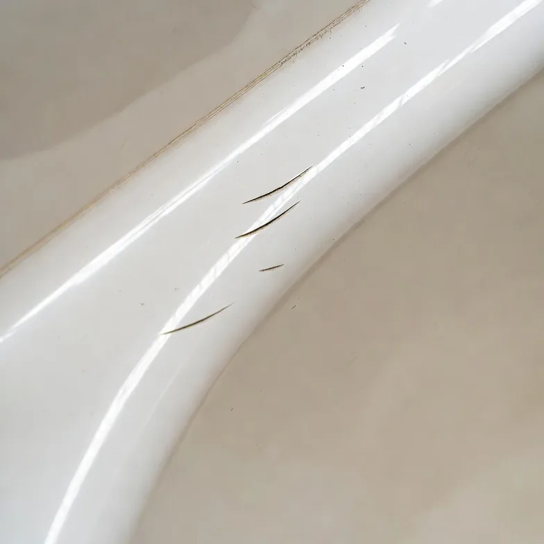 Close-up of acrylic tub scratch or gouge damage